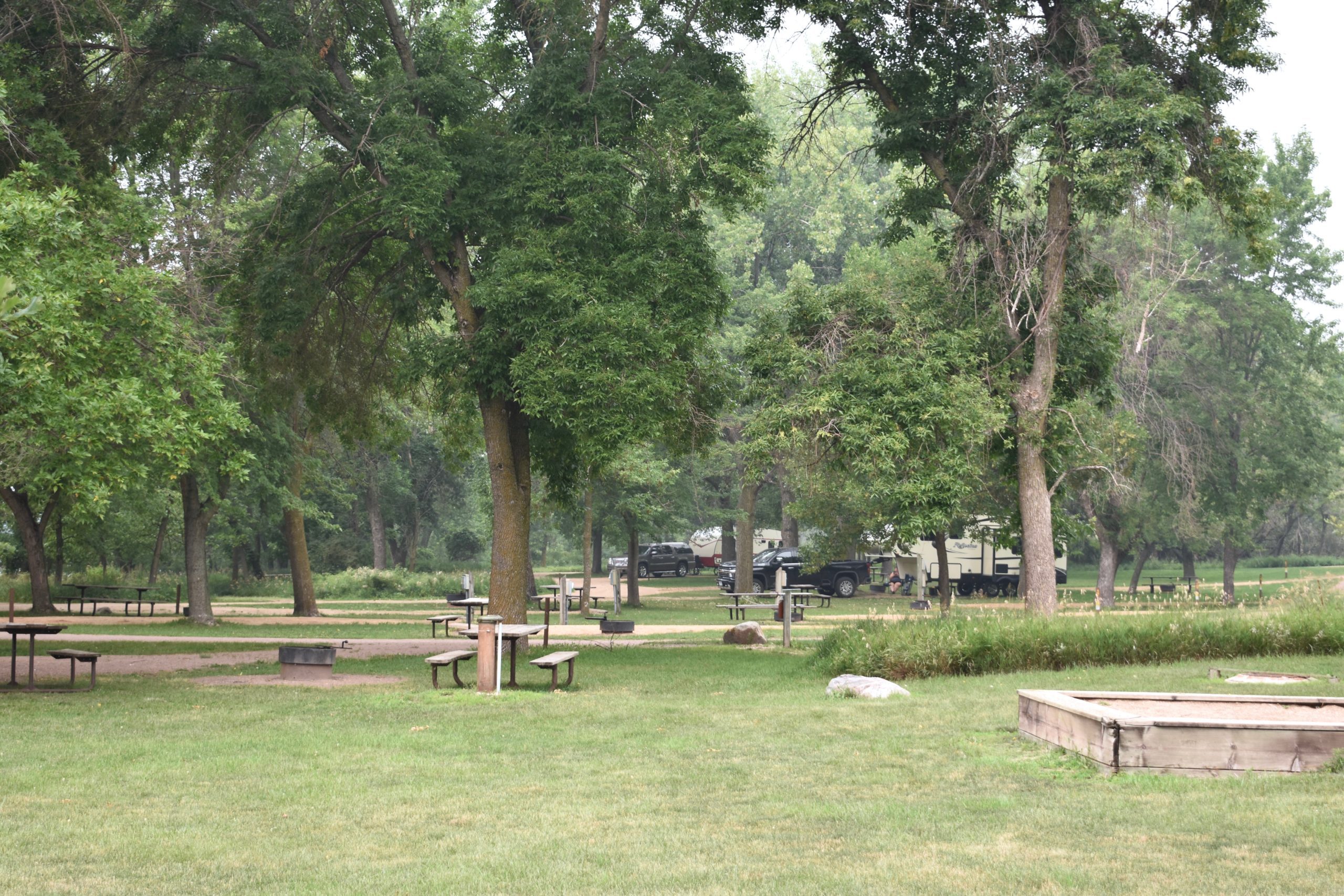 park campground with campers and picnic tables