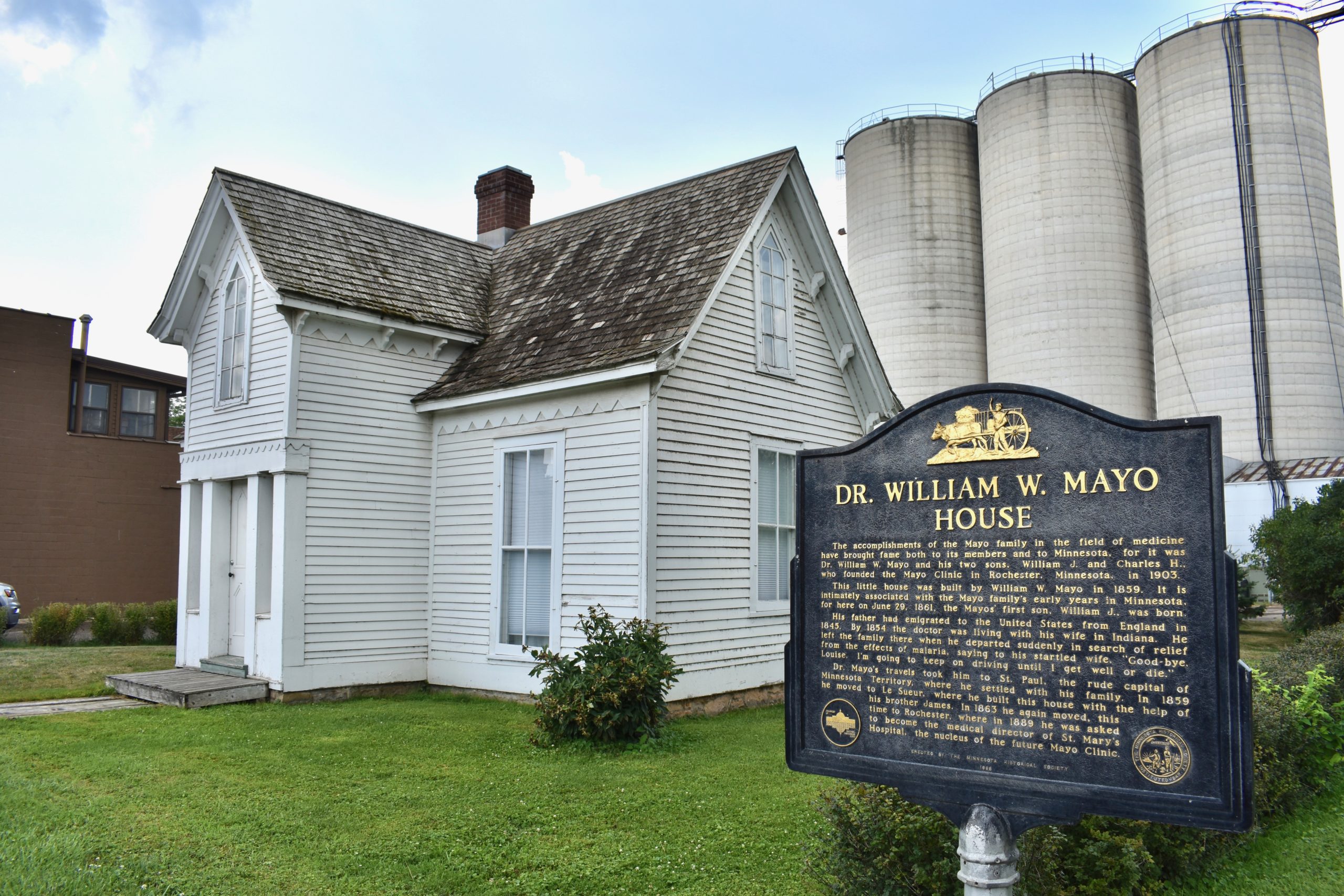 Mayo House informational plaque in foreground. House in background.