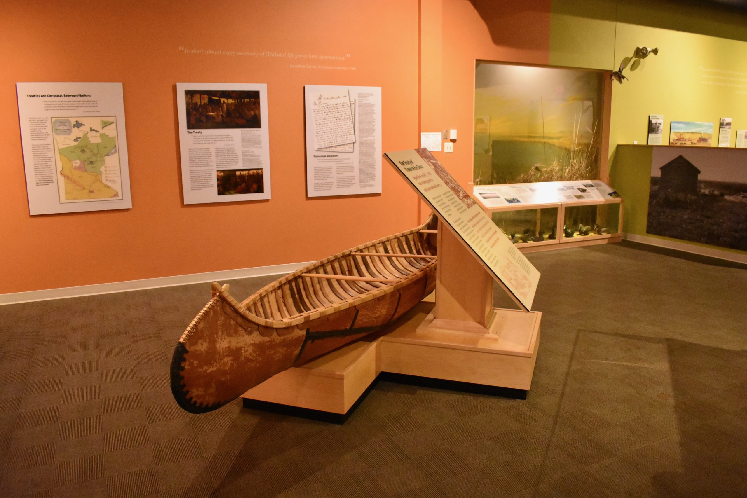 Wooden canoe in foreground. Informational displays in background.