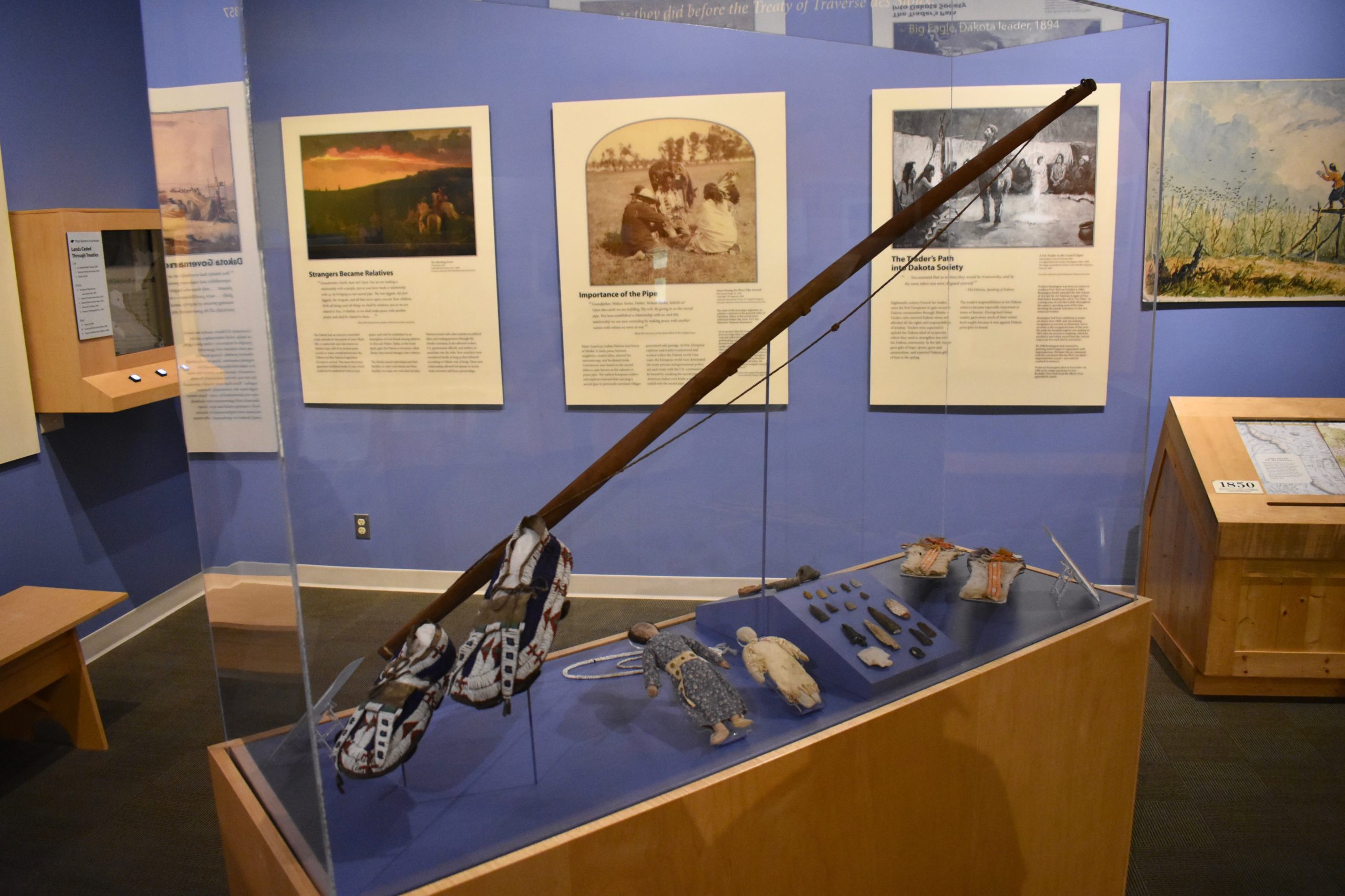 Native American artifacts in foreground. Informational displays in background.