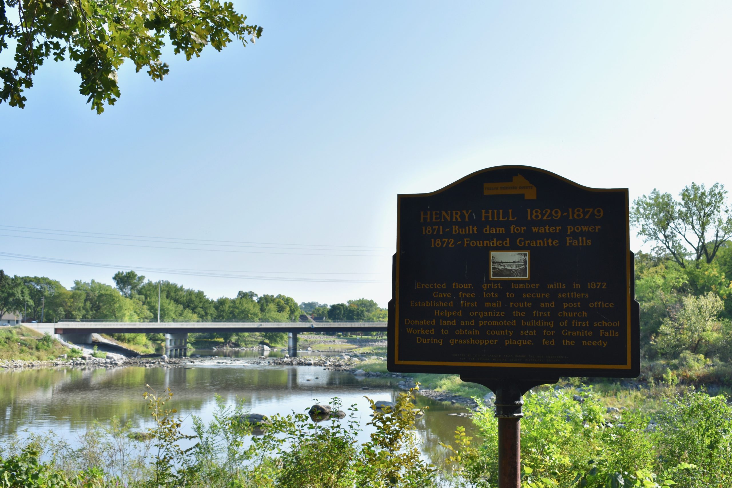 Henry Hill plaque in foreground. River and bridge in background