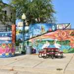 Staircase of colorful murals with picnic table in foreground