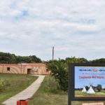 Welcome sign in foreground. Building in background