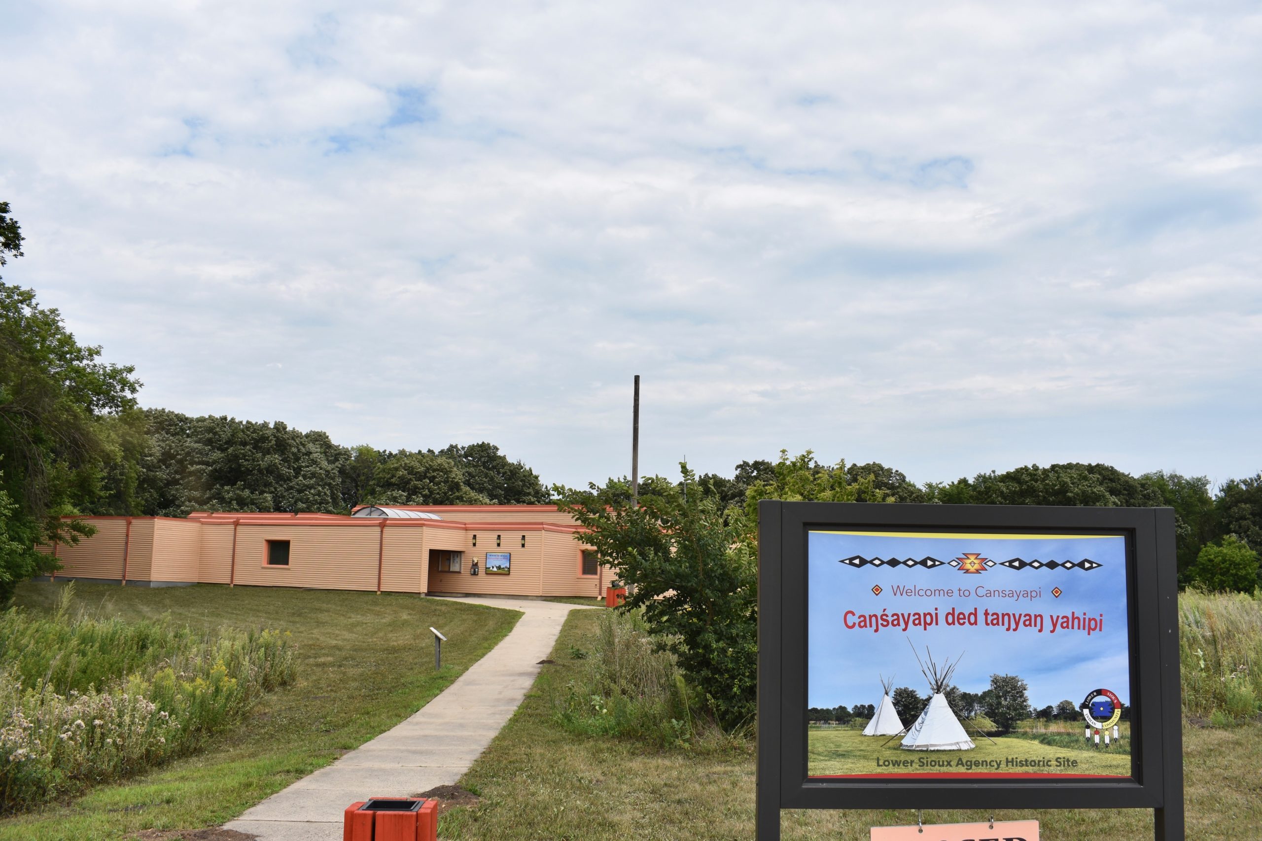 Welcome sign in foreground. Building in background