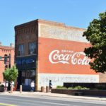 "drink Coca-Cola" mural on the side of brick building