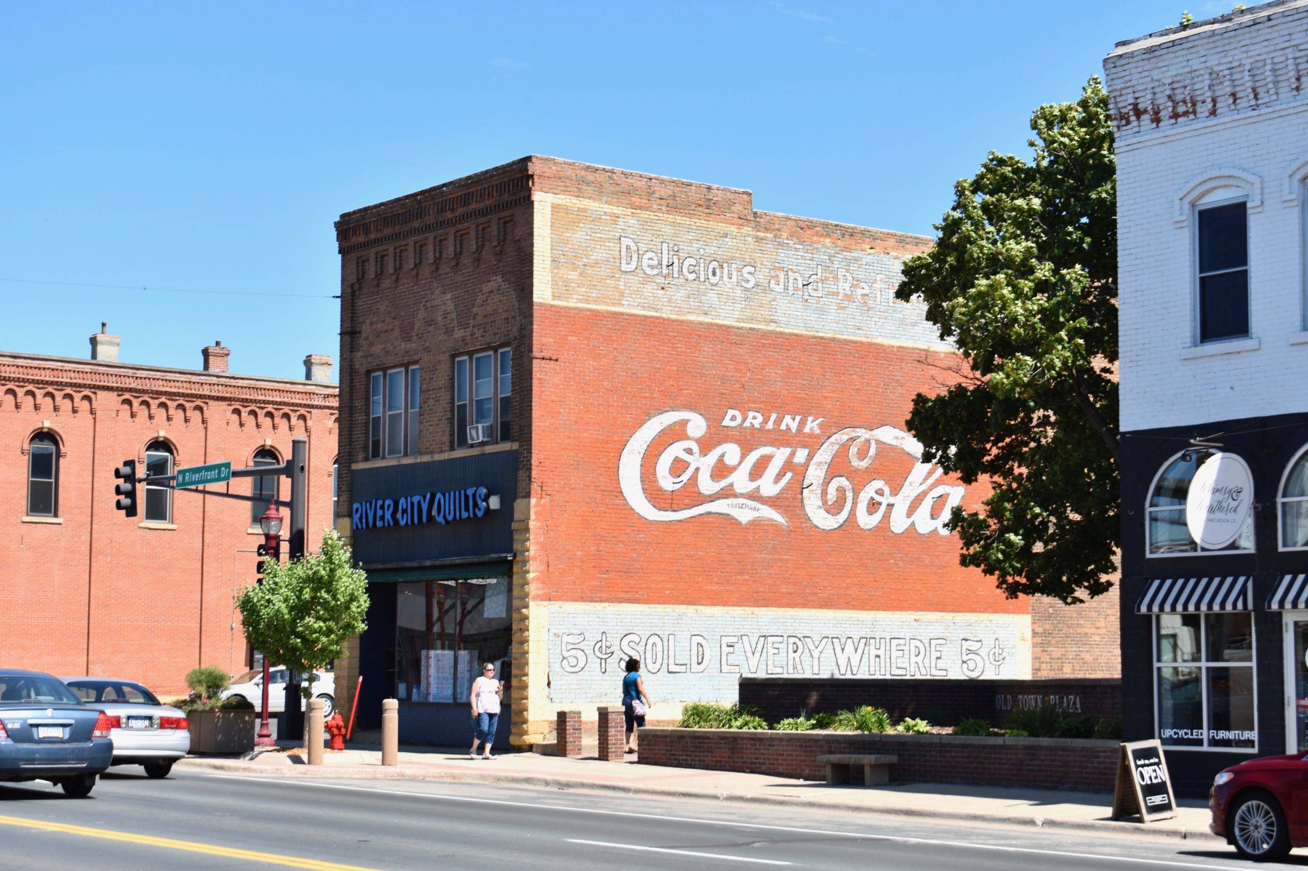 "drink Coca-Cola" mural on the side of brick building