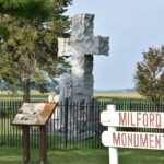 Milford Monument sign in foreground. Informational plaque and monument in background.