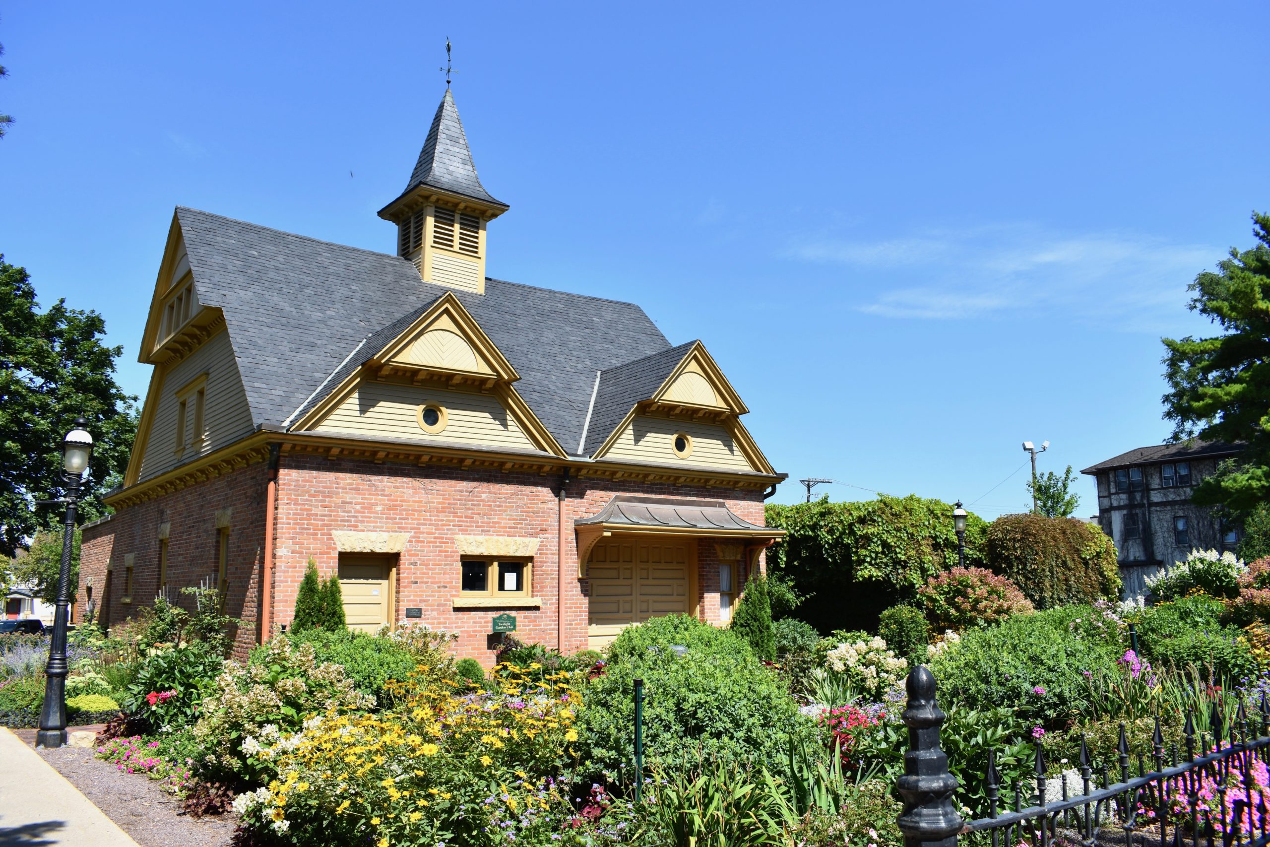 Flower garden in foreground. House in background.